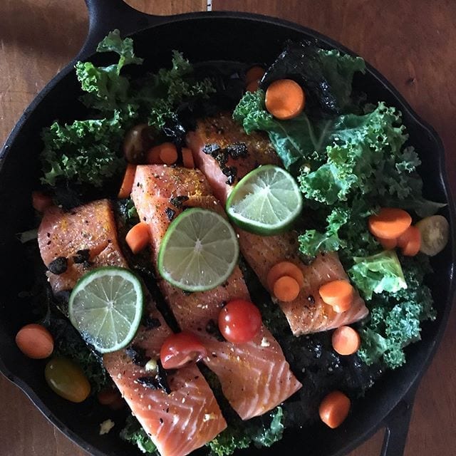 Easy 15 minute prep no excuses meal. Just Mouthwatering nutritious indulgence! Cast iron pan with organic tomatoes, carrots, kale, seaweed and wild caught salmon. On the